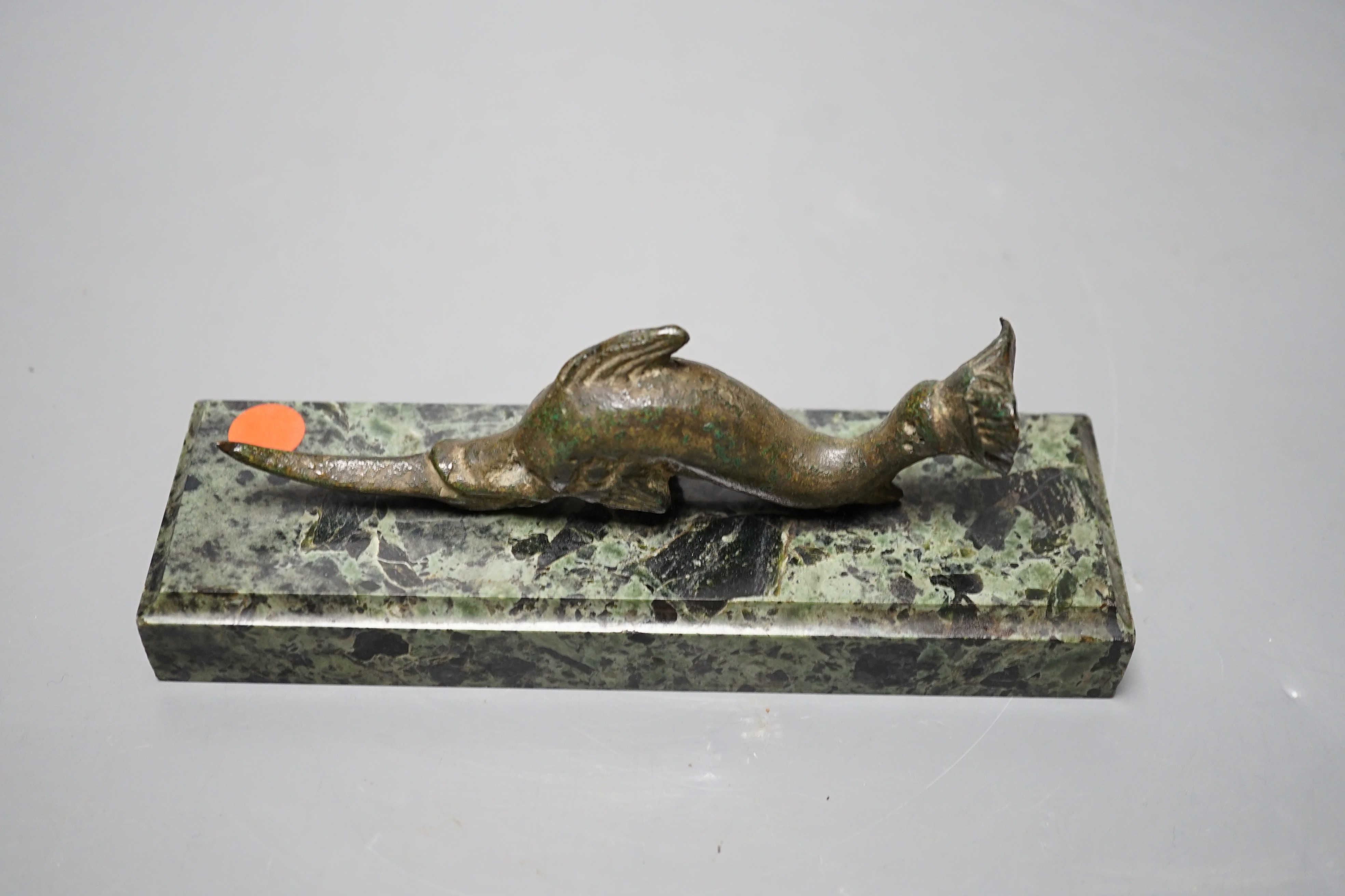 A Roman or later bronze dolphin, mounted as a paperweight on serpentine marble base, 16cm long